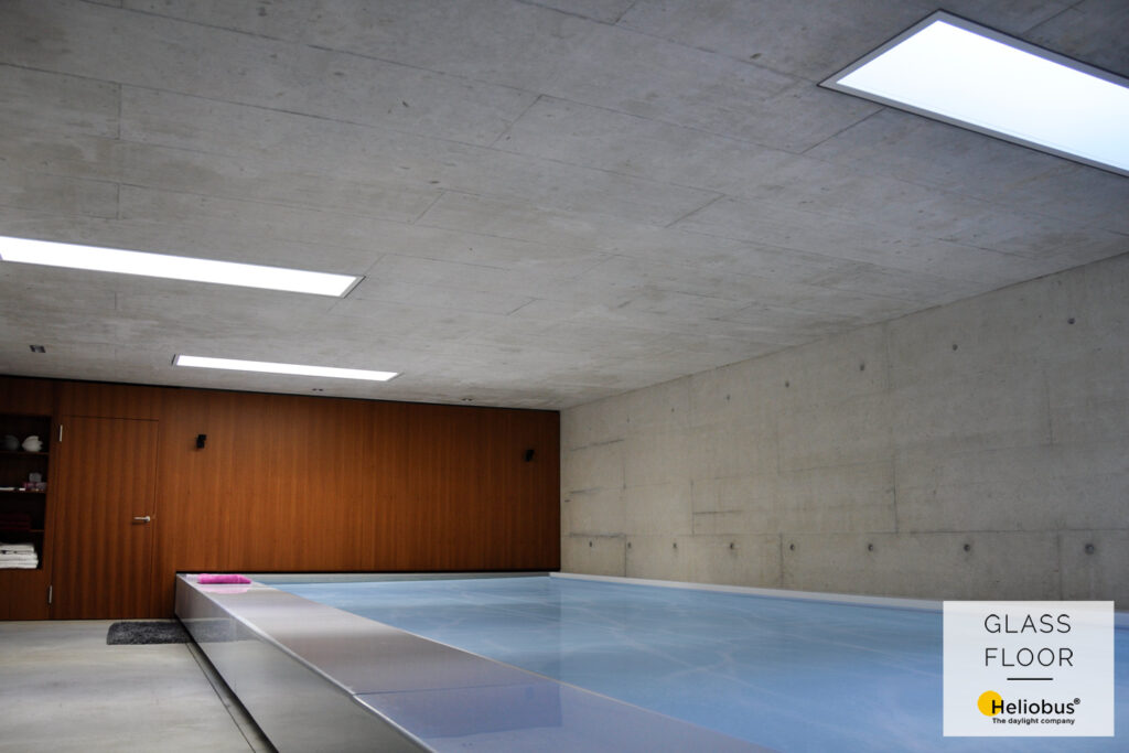 Vue intérieure d'une piscine en sous-sol avec une solution d'éclairage naturel de GLASSFLOOR by Heliobus