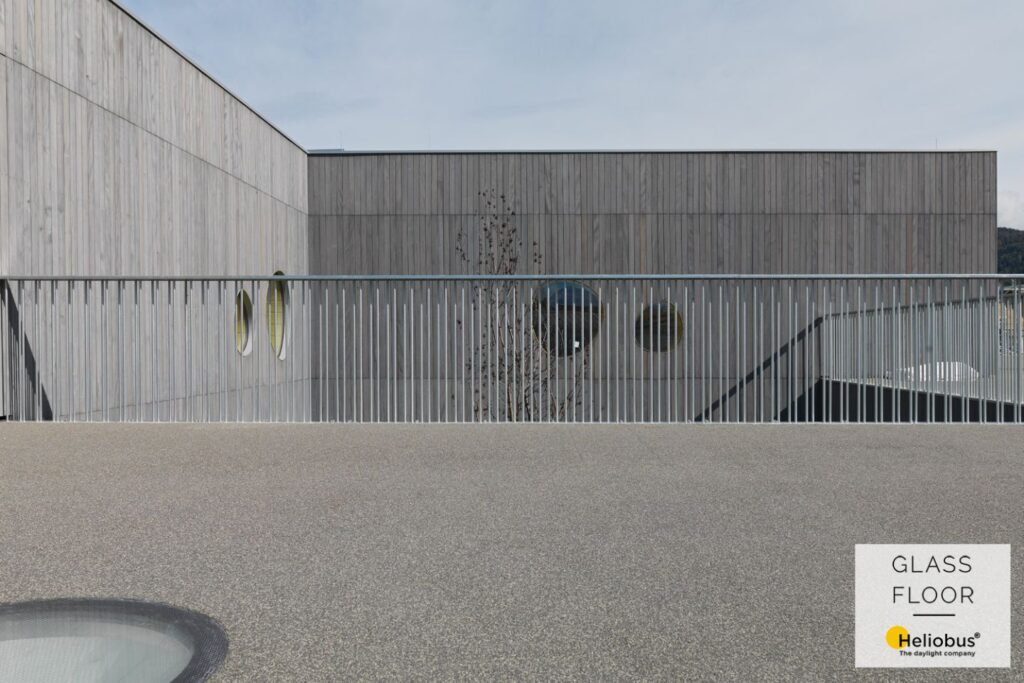 Terrasse von Schulhof um geben von Geländer mit Schulhaus im Hintergrund